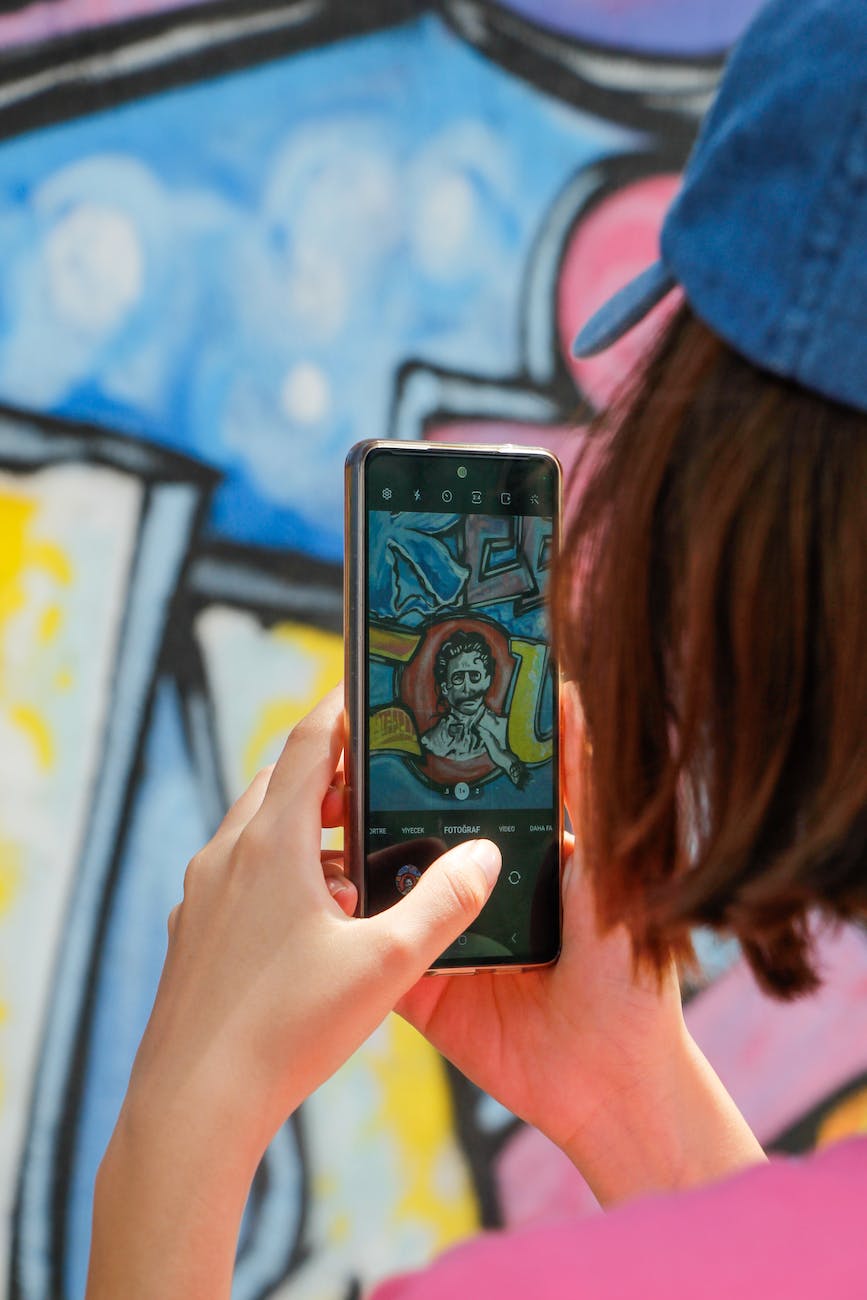 woman making a photo of a street art with her smart phone