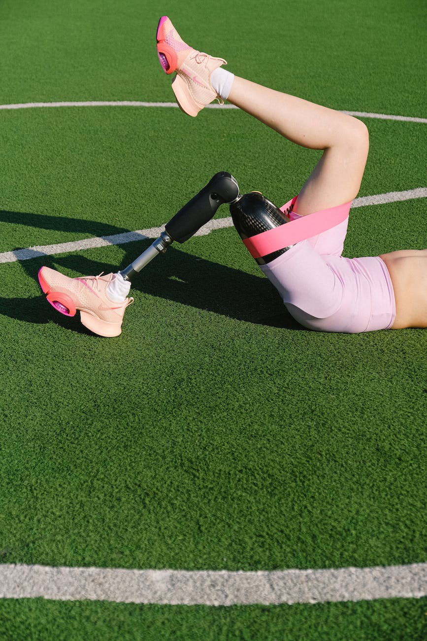 woman with a prosthetic leg exercising on a football pitch