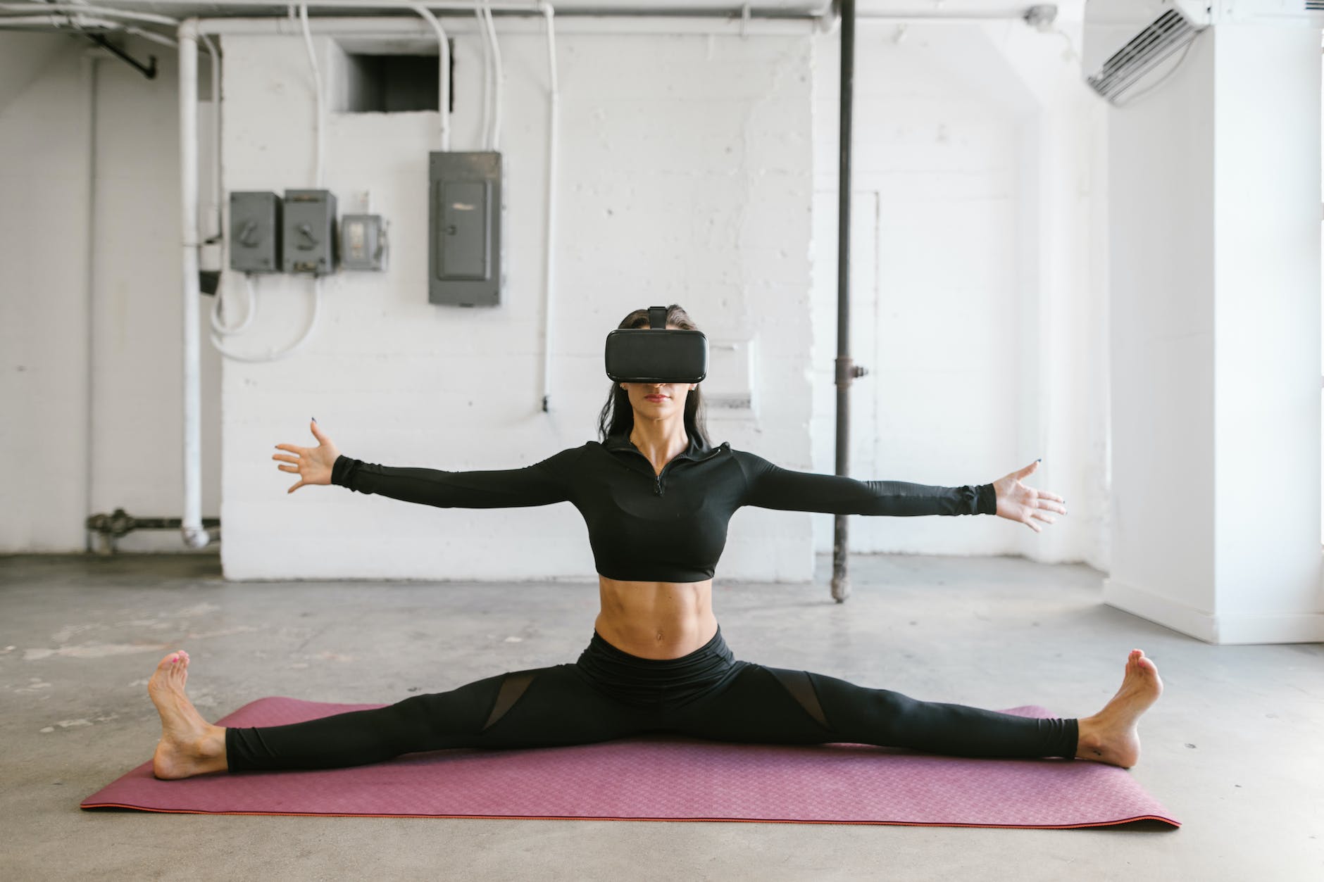 woman doing yoga while wearing virtual reality goggles