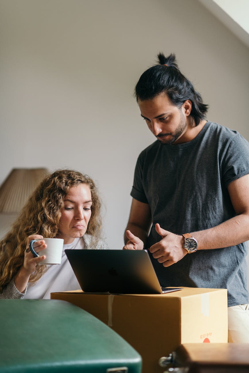young couple buying things for new house online using laptop