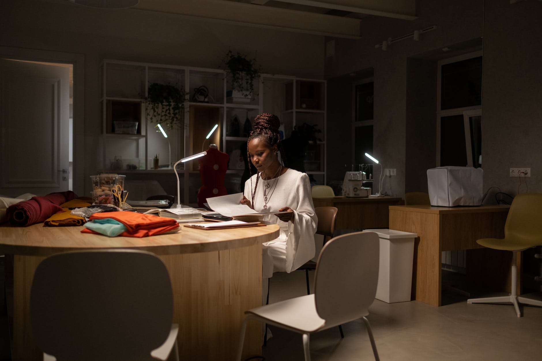 young african american fashion designer working late in sewing work space